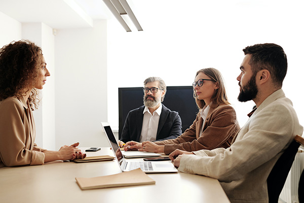 Group of men and women sitting around a table in a business setting