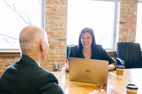 A man and a woman sitting around a table in a business setting