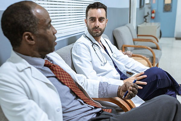 Two doctors sitting in a medical setting having a discussion